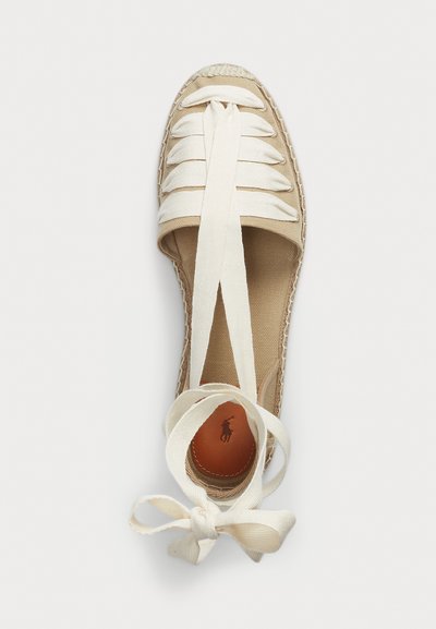 Espadrille de lona en beige con cintas de raso blancas, punta redondeada, ribete de yute trenzado y plantilla de cuero con logo en relieve.