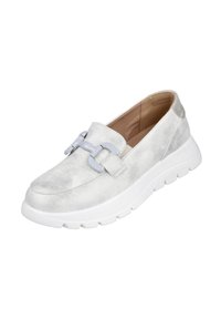 Zapato de ante gris claro, tipo slip-on, con una puntera ancha y lisa. Presenta un adorno decorativo de cadena gris y una suela gruesa blanca con agarres texturizados.