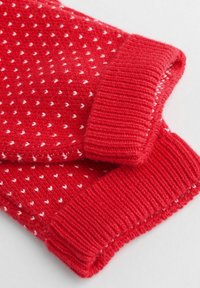 Rotes gestricktes Kleidungsstück mit gerippten Bündchen. Es weist ein Muster aus kleinen weißen Herzen auf einem strukturierten Hintergrund auf. Weiche Textur und warmes Design.