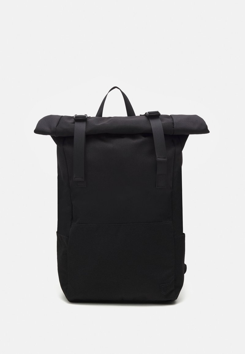 Sac à dos noir à rabat enroulable avec bretelles réglables, poche avant et poignée supérieure, présenté sur un fond blanc.