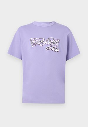 Μπλούζα με στρογγυλή λαιμόκοψη και κοντά μανίκια σε λιλά απόχρωση, με ανάγλυφο λευκό και μαύρο λογότυπο "Versace Jeans Couture" στο κέντρο του στήθους.