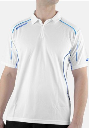Uomo che indossa una polo bianca a maniche corte con loghi Babolat blu e piping blu su spalle e lati.