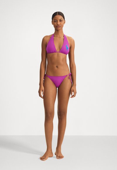 Bikini violet cu halter, cu un top triunghiular și șnururi ajustabile. Caracteristici un logo brodat albastru pe top. Material neted, elastic.