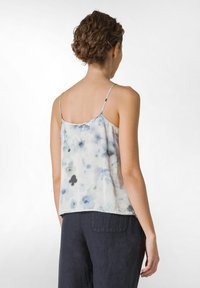 Top leggero senza maniche con un motivo floreale ad acquerello in delicati toni di blu e bianco. Caratterizzato da spalline sottili e una vestibilità comoda.
