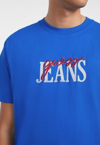 Guess Jeans TEE - Camiseta estampada - blau