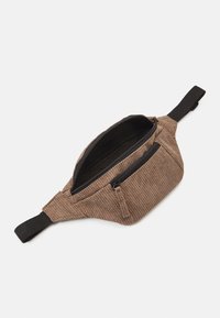 Ruskea corduroyfanny pack mustilla vetoketjuilla, jossa on yksi pääosasto ja pienempi etutasku, säädettävä hihna käyttöön.