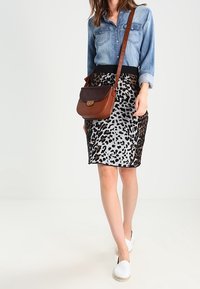 Jeansskjorta, svart midjeband, leopardmönstrad kjol i grått och svart, brun axelväska, vita espadriller. Enkel design, avslappnad stil.