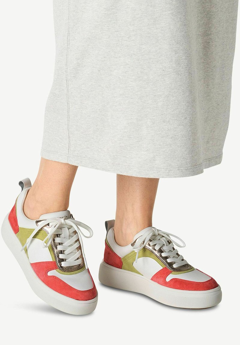 Multicolored sneakers featuring white leather, red and green suede accents, metallic accents, and white textured sole with laces.