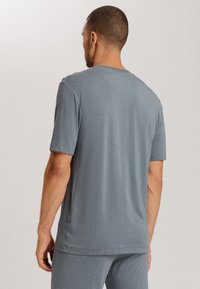 T-shirt grigio a maniche corte realizzato in tessuto leggero. Presenta un collo rotondo e una vestibilità rilassata, con una texture liscia e cuciture minime.