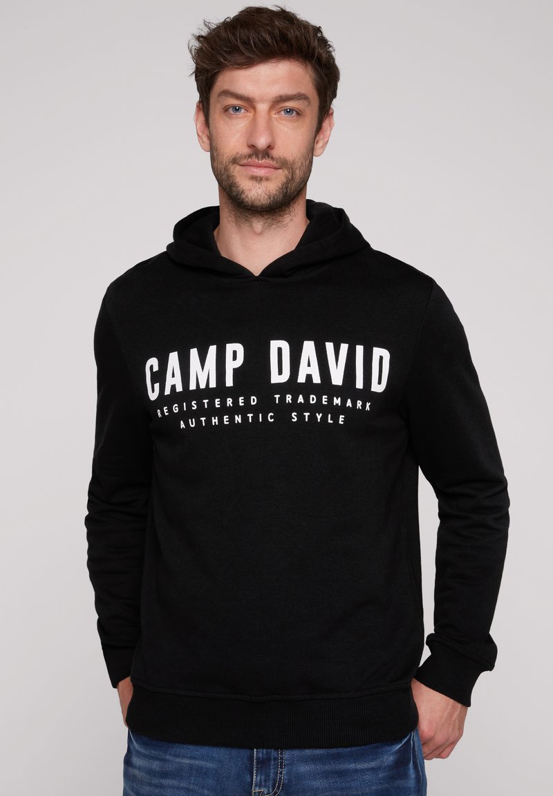 Sudadera negra de mezcla de algodón con gráfico frontal "CAMP DAVID" en letras grandes blancas. Cuenta con capucha con cordón y puños acanalados.