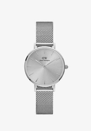 Ezüst hálós szíjjal rendelkező óra, kerek, matt ezüst számlappal, minimalista órajelekkel és márkás felirattal. Az oldalán koronával rendelkezik.