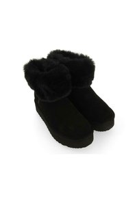 Botas negras de tobillo hechas de ante con un puño de piel de lujo, punta redonda y suela texturizada, que presentan un diseño minimalista.