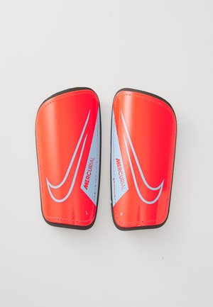 Protège-tibias Nike Mercurial, en plastique rouge avec des accents bleus, de forme courbée, surface légèrement texturée, étiquetés 'G' et 'D' pour gauche et droite.