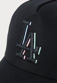 Zwarte pet met een gestructureerd geborduurd LA-logo in meerdere kleuren: pastelroze, blauw en groenaccenten aan de voorkant.