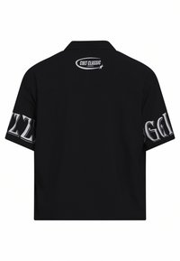 Μαύρο κοντό μανίκι πουκάμισο με γιακά. Διαθέτει γραφικό κείμενο σε λευκό στα μανίκια και στην πλάτη. Λείος ύφασμα.