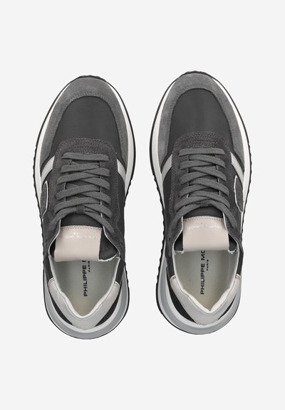 Pair of dark gray and black sneakers with white accents, laces tied, and branded inner soles, shown from a top-down view.
