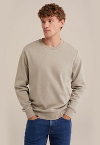 Heled hall sweatshirt, mis on valmistatud pehmest kangast. Omab soonikest krae ja varrukate otstes, ning on lõdva lõikega. Sobib siniste teksadega.