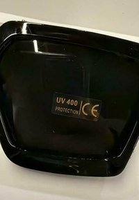 Schwarzes Sonnenbrillenglas mit Aufkleber, der UV-400-Schutz und CE-Zertifizierung für europäische Sicherheitsstandards anzeigt.