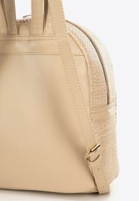 Borsa beige in pelle liscia con texture intrecciata. Presenta una forma strutturata, doppio manico e una chiusura con zip in metallo dorato.