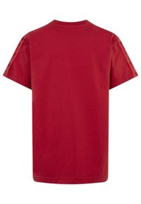 T-shirt in cotone rosso con collo tondo, maniche corte e vestibilità rilassata. Texture liscia senza motivi o accenti visibili.