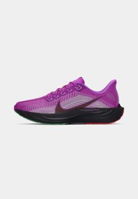 Chaussure de course violette avec tige en mesh, semelle intermédiaire noire contrastante et accents colorés sur la semelle extérieure. Dispose de lacets et d'un logo Swoosh de Nike.