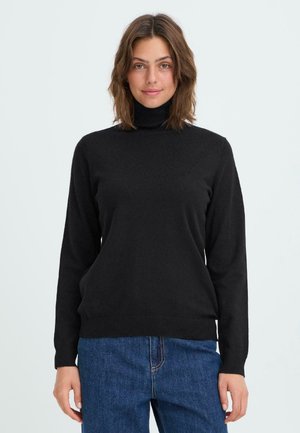 Maglione dolcevita nero realizzato in morbido tessuto lavorato a maglia, con maniche lunghe e polsini e orlo a coste. Abbinato a jeans blu.