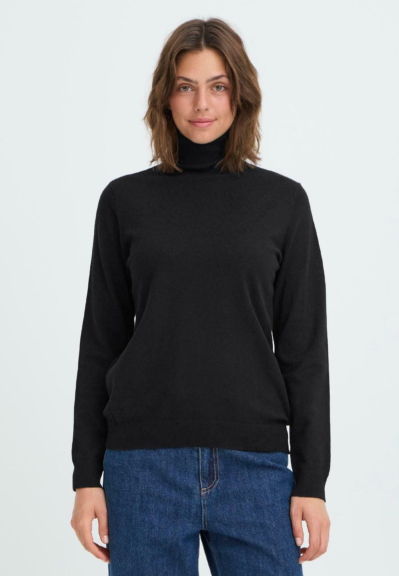 Schwarzer Rollkragenpullover aus weichem Strickstoff, mit langen Ärmeln und gerippten Bündchen und Saum. Getragen mit blauen Jeans.