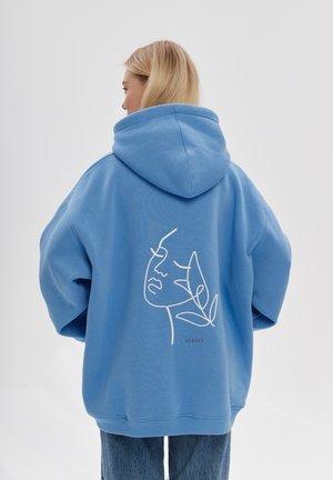 Oversized blauwe hoodie met een trekkoordcapuchon, met op de achterkant een witte lijntekening van een gezicht en bladeren. Gemaakt van katoen.