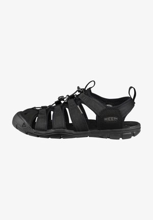 Black outdoor sandal featuring a breathable fabric upper, adjustable straps, a rubber sole, and toe protection. Designed for durability and comfort.