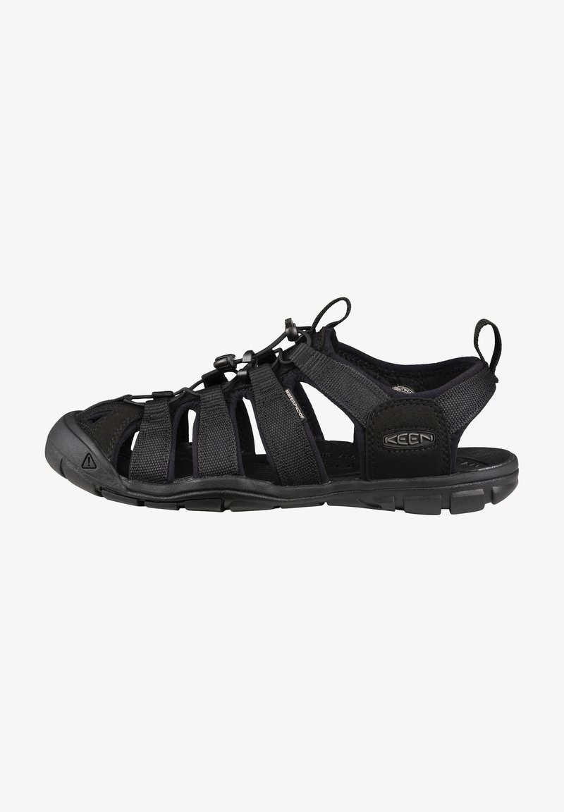 Black outdoor sandal featuring a breathable fabric upper, adjustable straps, a rubber sole, and toe protection. Designed for durability and comfort.