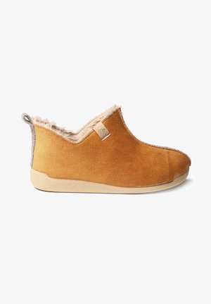 Tan instapslippers met een zachte, textuur op de bovenkant, beige fleece binnenvoering en een lichtgekleurde rubberen zool. Bevat een klein logo aan de zijkant.