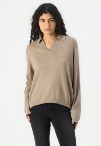 Maglione in misto lana beige con colletto, maniche lunghe e vestibilità rilassata, caratterizzato da una leggera trama e orlo a costine.
