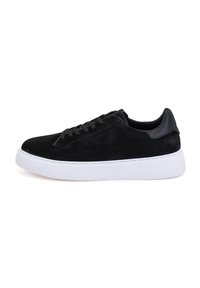 Schwarze Wildleder-Sneaker mit einer weißen Gummisohle, runder Zehenform und kontrastierenden Akzenten aus schwarzem Leder an der Ferse. Ausgestattet mit flachen schwarzen Schnürsenkeln und minimalistischem Design.