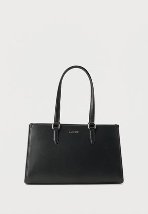 Black textured leather tote bag with two shoulder straps and silver Lacoste logo on front center against a plain background.