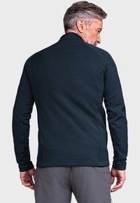 Dunkelblaues Fleece-Jackett mit einem Reißverschlusskragen, langen Ärmeln und einer glatten Textur. Verfügt über Seitentaschen und gerippte Bündchen.