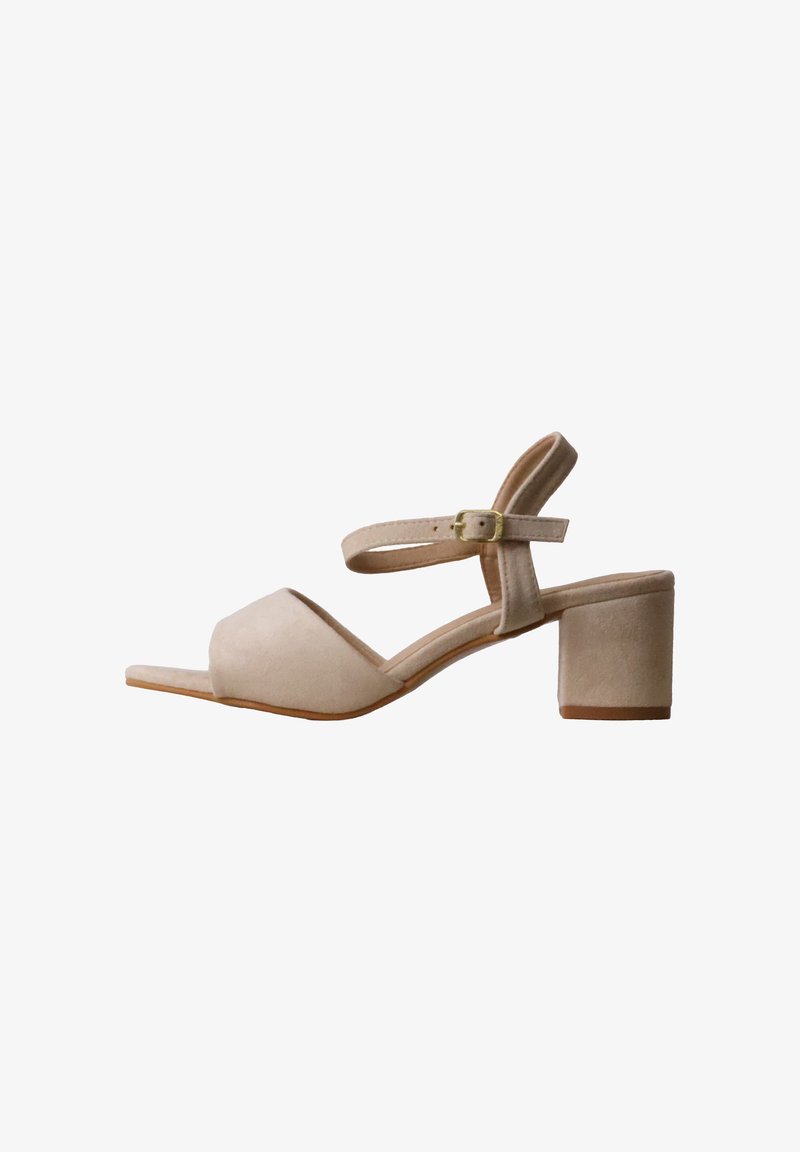 Sandale beige en daim pour femme avec bout ouvert, talon bloc et bride de cheville ajustable avec boucle dorée.