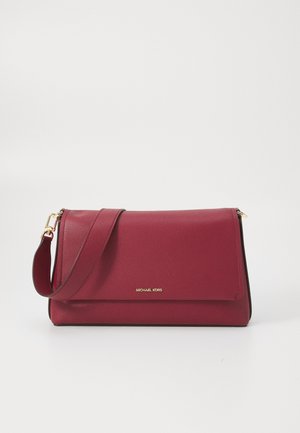 Crimson leather crossbody bag with a flap closure, gold hardware, and adjustable strap. Features subtle logo detailing on the front.