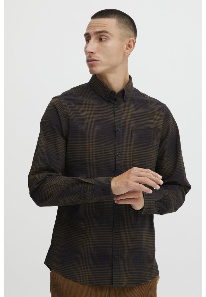 Long-sleeved shirt in dark brown with a subtle grid pattern, featuring a button-down collar, front buttons, and cuffs. Smooth fabric texture.