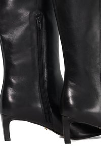 Black leather knee-high boots with a smooth texture, zip closure on the side, and a thin heel. Elegant design suitable for various outfits.