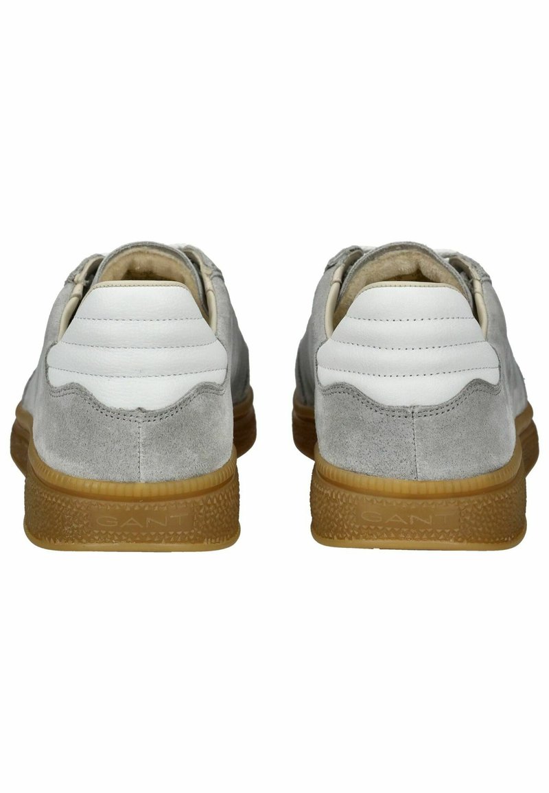 Jasnoszare zamszowe trampki z białymi, teksturowanymi skórzanymi akcentami. Gumowa podeszwa w kolorze brązowym z logotypem "GANT", z zaokrąglonym tyłem.