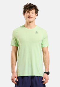 Lichtgroen sport t-shirt van een gemêleerde mesh-stof. Heeft een ronde hals en korte mouwen. Logo op de bovenste linkerkant.