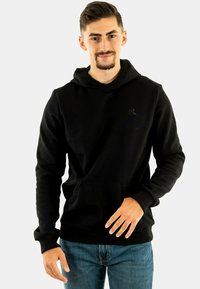 Sudadera negra hecha de una tela suave con capucha ajustable, bolsillo delantero y puños de canalé. Presenta un logo sutil en el pecho.