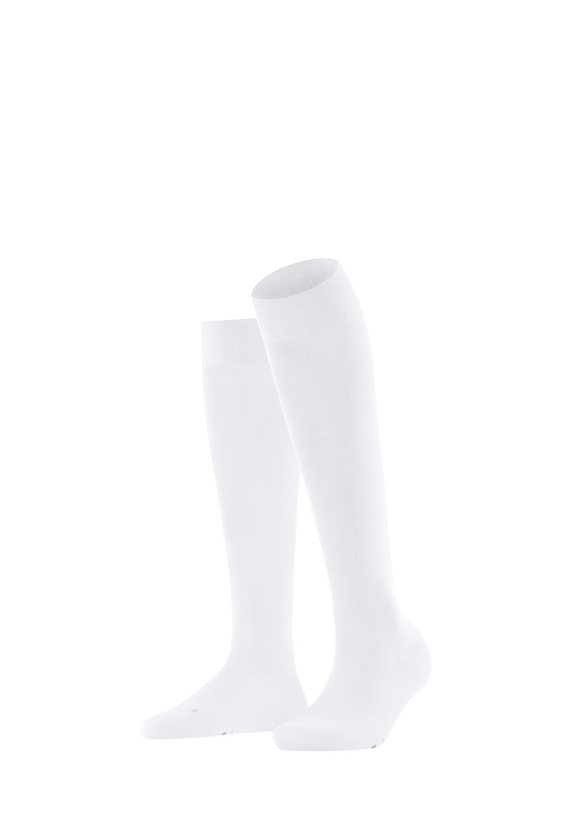 Een paar eenvoudige witte kousen tot de knie staan rechtop op een witte achtergrond, en tonen de textuur en geribbelde bovenkanten.