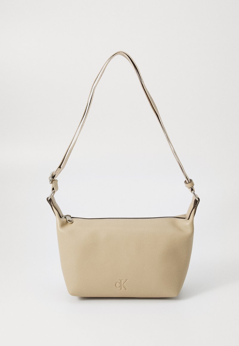 Beige leather shoulder bag with a smooth texture, a zip closure, and a logo accent. Adjustable strap with silver-tone hardware.