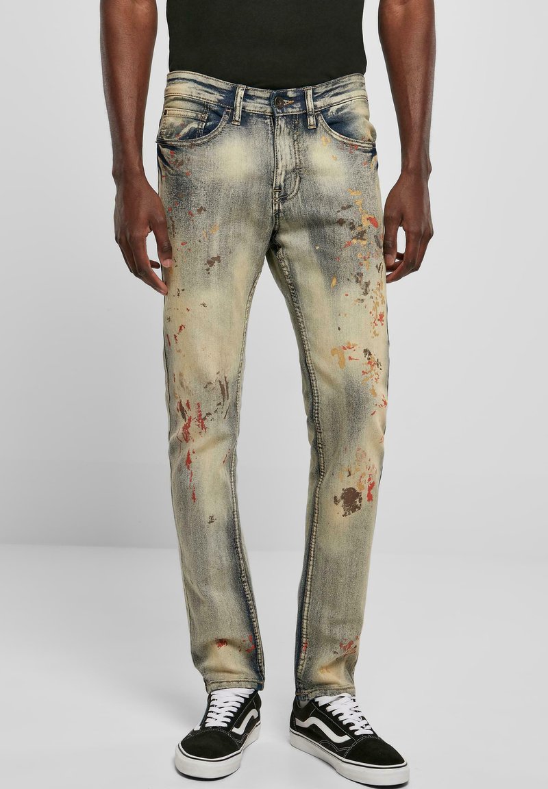 Fadede blå denimjeans med slim fit, med flerfargede malingssprut og klassisk fem-lomme-design.