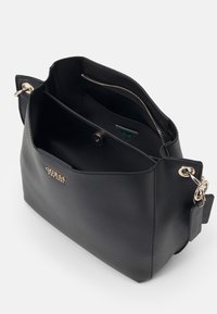 Czarna skórzana torebka o gładkiej fakturze. Posiada złote okucia, kieszeń na suwak oraz wewnętrzne przegrody do organizacji.