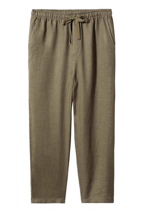 Col roulé sans manches en maille crème avec motif texturé, associé à un pantalon ample olive et des bottines à talons couleur sable.