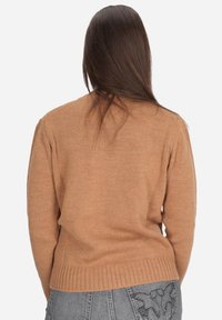 Maglione lavorato a maglia color marrone chiaro con orlo e polsini a coste, caratterizzato da un design semplice e una texture morbida, visto da dietro.