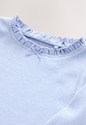 Lyseblå sweater med en flæsekrave og en lille dekorativ sløjfe ved kraven. Blødt, tekstureret stof med et hyggeligt udseende.