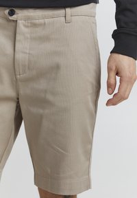 Khaki shorts lavet af tekstureret stof, med knaplukning foran, sidelommer og opfoldet kant. Glat fornemmelse og skræddersyet pasform.